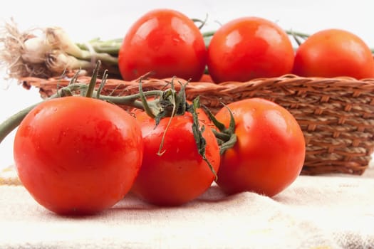 Red tomatoes in a basket on a white background