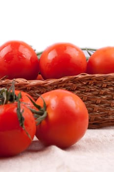 Red tomatoes in a basket on a white background