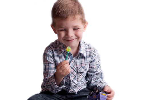 A little boy with candy on a white background