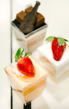 cheese cake with  strawberries,  decorated with fresh strawberries and chocolate , served in a bowl with a small