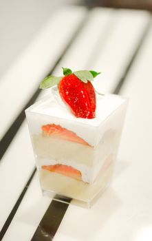 cheese cake with  strawberries,  decorated with fresh strawberries , served in a bowl with a small