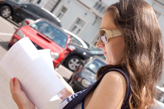 girl tourist with a map of walks around the city Shooting outdoors