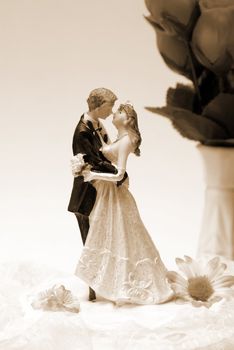 A wedding cake topper in a sepia toned image.