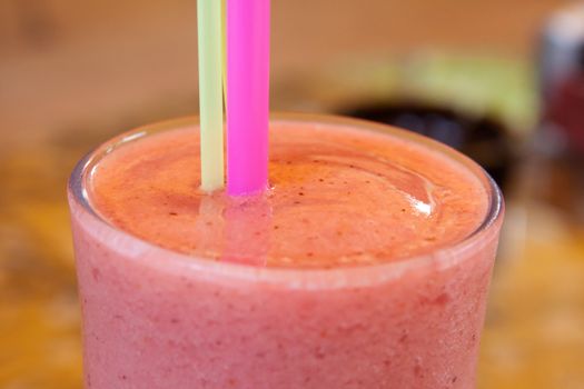 Fruit milk shake with a straw in a cafe shooting