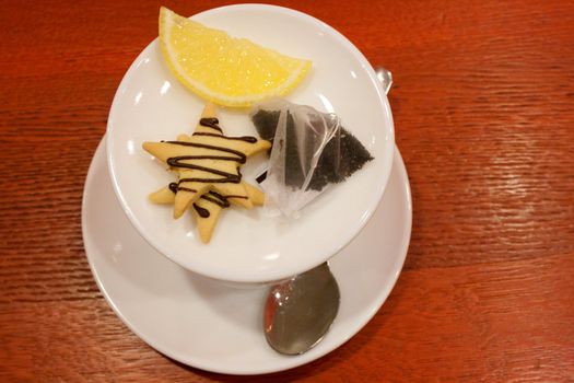 Tea bags, lemons, cookies, cup and spoon in a cafe shooting