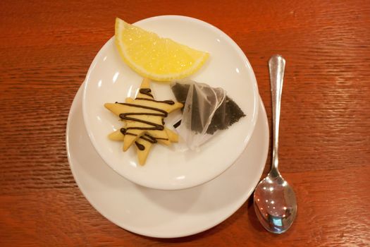 Tea bags, lemons, cookies, cup and spoon in a cafe shooting