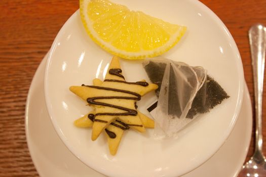 Tea bags, lemons, cookies, cup and spoon in a cafe shooting