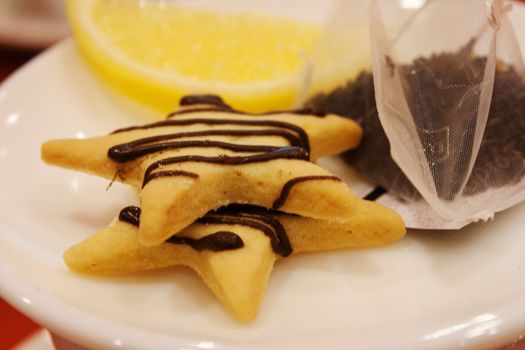 Tea bags, lemons, cookies, cup and spoon in a cafe shooting