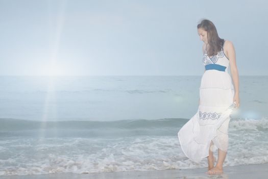 A girl stands on the beach and looks down on nature photography