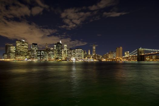 The New York City skyline at night w Brooklyn Bridge