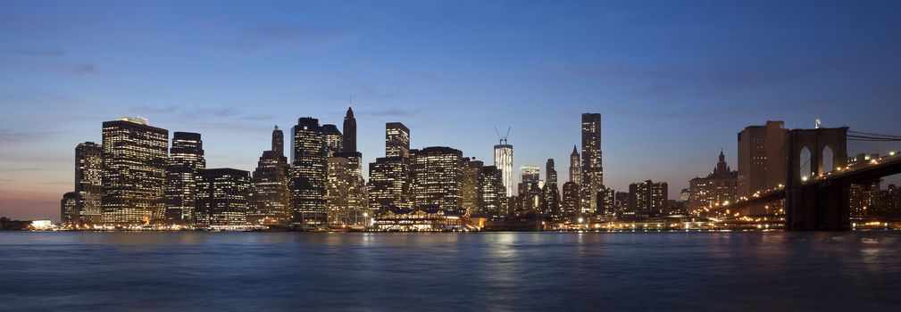 The New York City skyline at twilight w Brooklyn Bridge