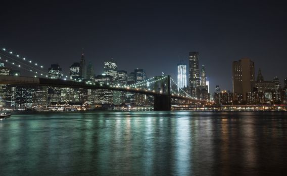 The New York City skyline at night w Brooklyn Bridge