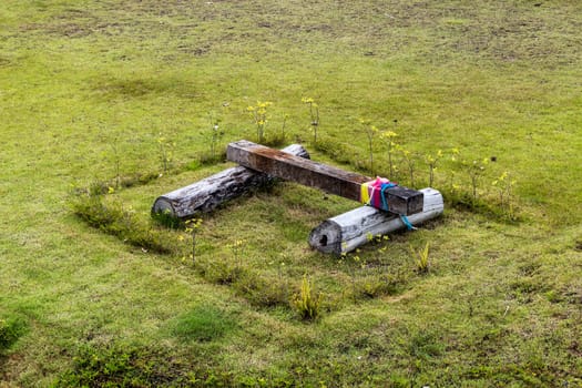 Logs placed on the ground tied with piece of colorful fabric.