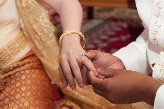 putting engage ring for bride in thai wedding ceremony