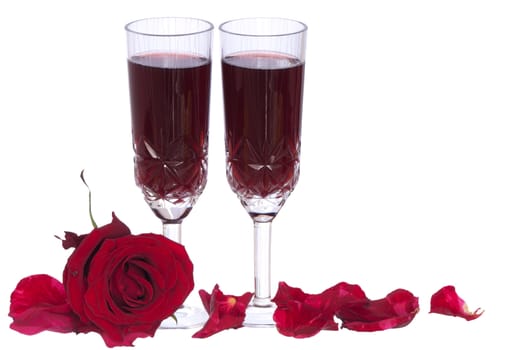 two tumblers of champagne with red rose on the party