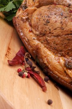 Ripe Spicy Roasted Pork with Herbs and Chili closeup on Cutting Board