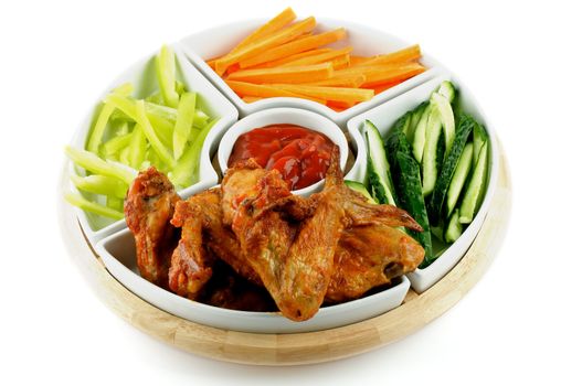 Chicken Wings with Barbecue Dressing, Cucumber, Bell Pepper and Carrot Sticks on Plate isolated on white background