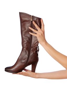brown female boots in hands at the saleswoman