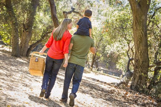 Happy Mixed Race Family with Picnic Basket Enjoy a Walk in the Park.