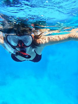 Woman swimming under water in snorkeling mask for looking marine life