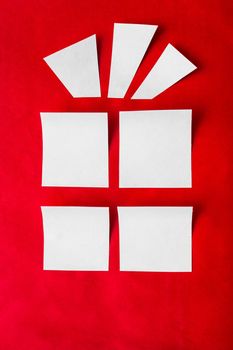 outline a Christmas gift of a white paper on a red background