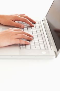 Two hands lying on keyboard of laptop