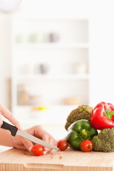 Woman's hands slicing tomatoes in a kitchen