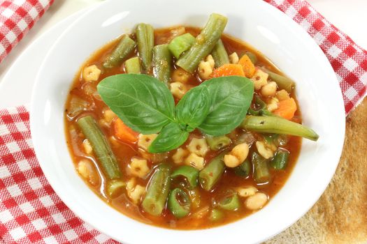 a bowl of minestrone soup and basil