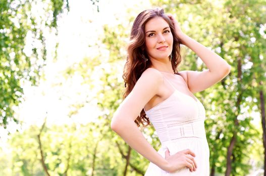 Portrait of an attractive woman in the park, her hair and smiling