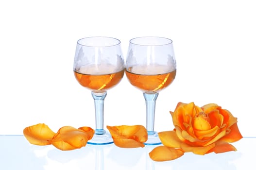 two tumblers with white wine and yellow rose on the party