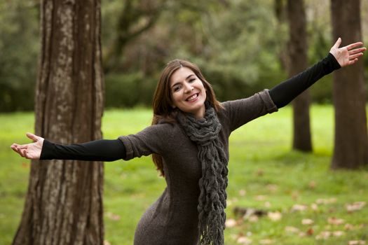 Portrait of a beautiful young woman relaxing with arms open and enjoying the nature