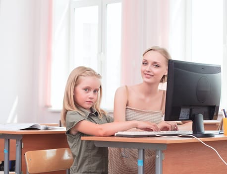 teacher explains the task schoolgirl at the computer, the new technologies in education