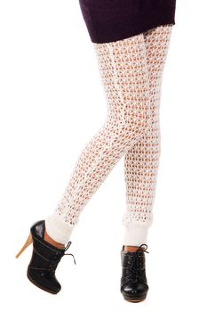 Woman's legs in a knitted leggings against white background