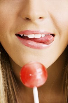 Closeup photo of a young woman tasting a candy