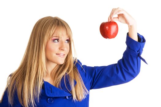 Young woman in blue autumn coat holding a red apple