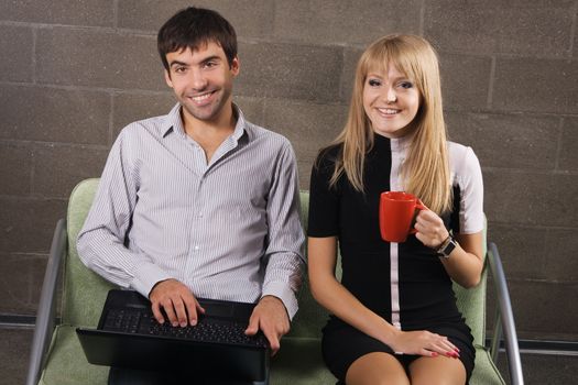 Young man and woman sitting with a laptop indoors