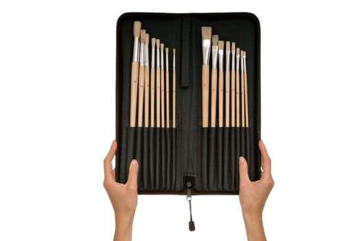 The woman chooses from a set of brushes one for drawing
