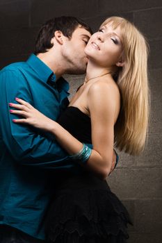 Young romantic couple kissing in house interior