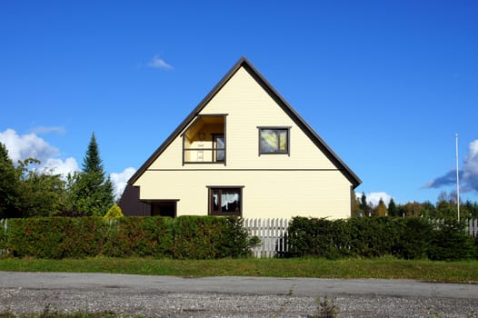 The house and field on a background of the sky