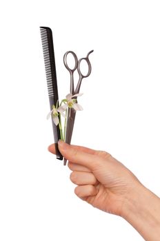 hairdresser holds the snowdrops and tools for haircut