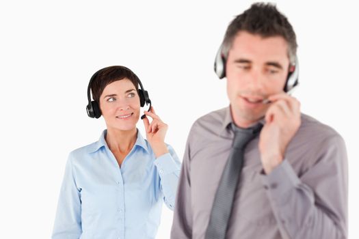 Business people speaking through headsets against a white background