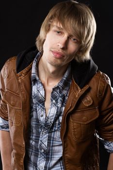 Handsome young man in leather jacket, studio portrait