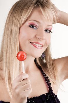 Funny young woman with a lollipop, white background