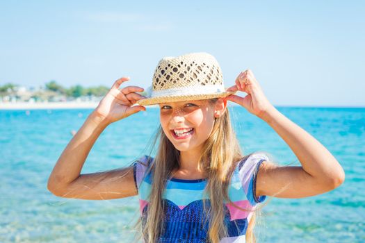 Close up portrait of happy beautiful girl in the beach hat relax near the sea