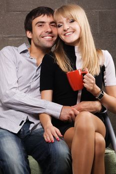 Young cheerful couple on brick wall background