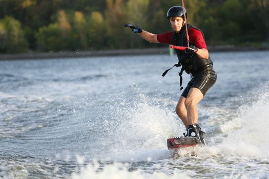Wakeboarder surfing across the river