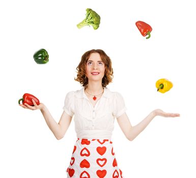 Young beautiful woman juggling with vegetables, white background