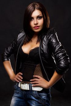 Sexy young woman in leather jacket, studio portrait