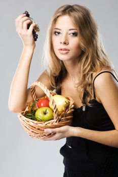 Portrait of a pretty woman with a basket of ripe fruit