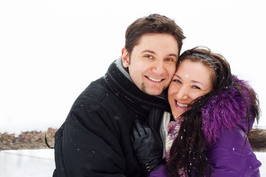 Young happy couple having fun in winter park 